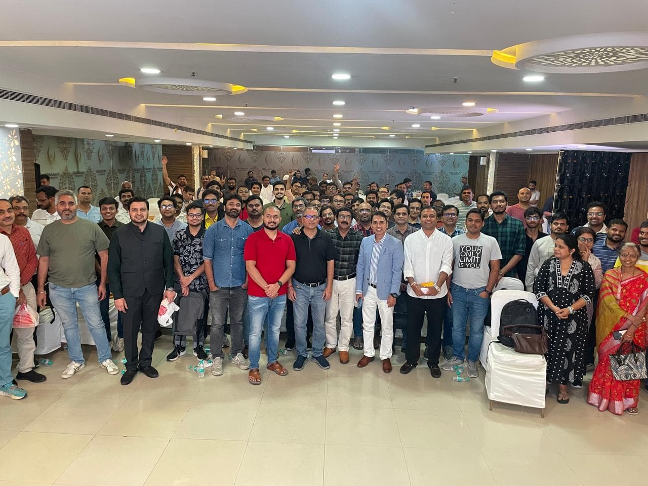 Around eighty attendees packed together for a group photograph filling the banquet hall at an HIE offline meet
